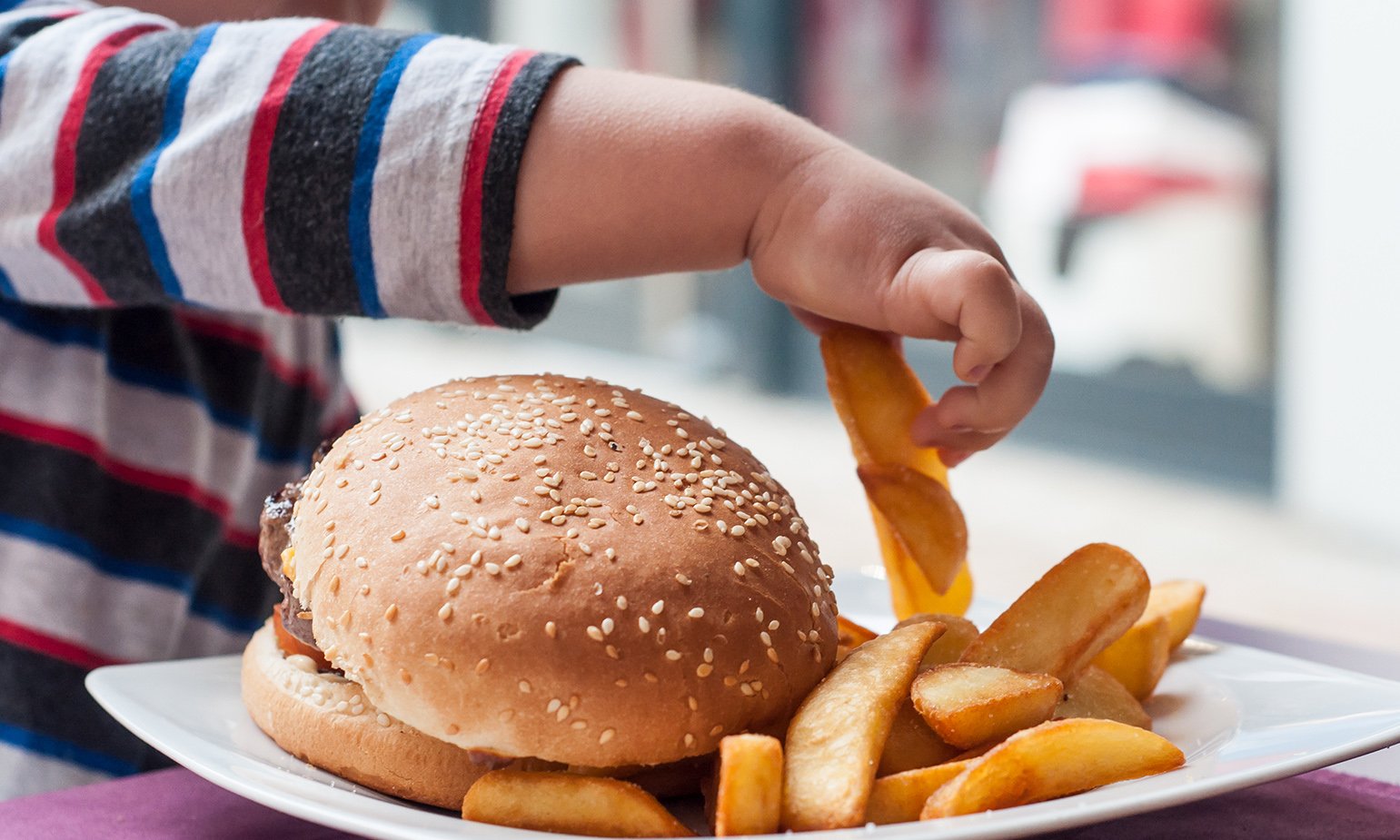 kid-grabbing-french-fry-from-hamburger-plate.jpg